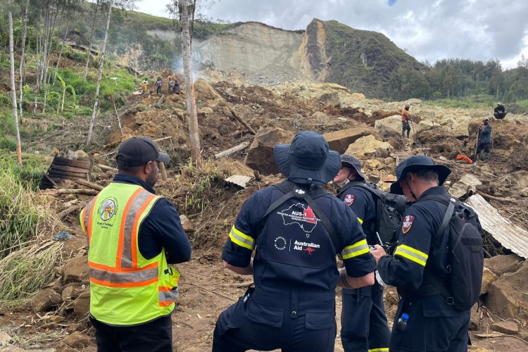A team of workers standling close to the landslide edge